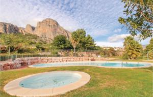 Ein großer Swimmingpool im Gras vor dem Hintergrund eines Berges in der Unterkunft Atalayas De Polop Iii in Polop