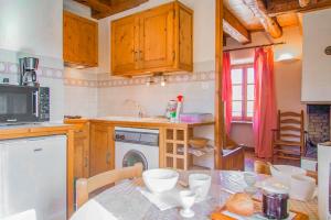 a kitchen with a table and a sink and a dishwasher at Gîte allier 2/3 personnes in Chasseradès