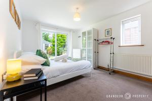 a bedroom with a bed and a window at Bracken Bliss by Grandeur Property in Ferndown