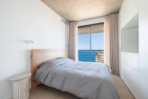 una camera da letto con un letto e vista sull'oceano di Villa Neuve, proche Monaco a Roquebrune-Cap-Martin Altre 11 foto