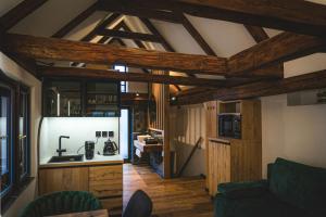 a living room with wooden ceilings and a kitchen at Parkan 127 Apartments in Český Krumlov