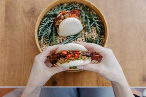 a person holding a sandwich in front of a basket of food at Vale d'El Rei Hotel & Villas in Carvoeiro