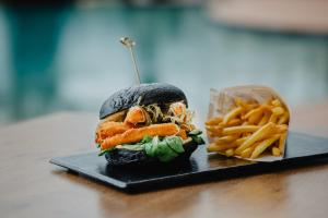 a sandwich and french fries on a black plate at Vale d'El Rei Hotel & Villas in Carvoeiro