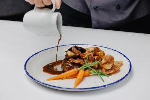 a plate of food with carrots and sauce on a table at Vale d'El Rei Hotel & Villas in Carvoeiro