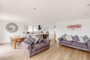 un soggiorno con due divani e un tavolo di Berryrigg Cottage a Dumfries