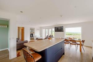 una cucina e un soggiorno con tavolo e sedie di Berryrigg Cottage a Dumfries