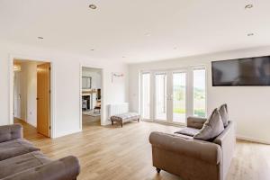 un soggiorno con due divani e una TV a schermo piatto di Berryrigg Cottage a Dumfries