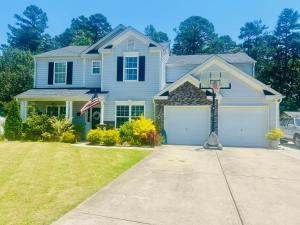 a blue house with a basketball hoop in the driveway at Cozy Bedroom Suites in Beautiful Shared Home in Matthews