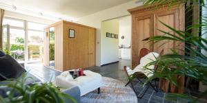 a living room with a white couch and chairs at Art'Aviation Guesthouse in Beauvechain