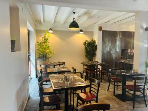 a restaurant with tables and chairs in a room at Au Relais Gascon in Labastide-dʼArmagnac