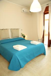 a blue bed with two towels on top of it at Casa A Riba U Mari in Riposto