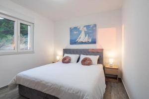 a bedroom with a large white bed with two pillows at Luxury Penthouse - Views, Hot Tub & Pool in Makarska +20 photos