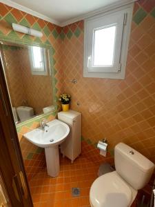a bathroom with a toilet and a sink at Palio Luxury Apartment in Paleo Tsifliki