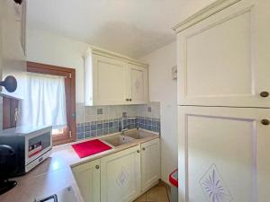 a kitchen with white cabinets and a sink at Villa del Golfo in Olbia