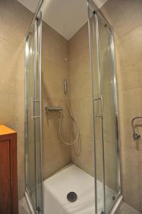 a shower with a glass enclosure in a bathroom at Historic center shelter in Piran