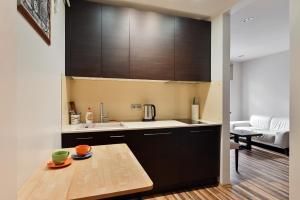 Modern Studio-apartment in the centre في ريغا: مطبخ بدولاب سوداء وطاولة خشبية