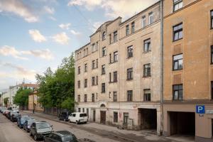 Modern Studio-apartment in the centre في ريغا: مبنى قديم على شارع المدينة مع سيارات متوقفة