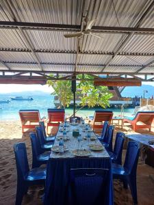 a table with wine glasses and chairs on a beach at 4 Sisters Divers in Bunaken +26 photos