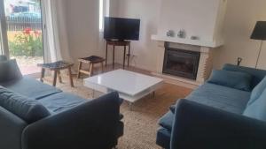 a living room with two blue couches and a fireplace at Seaview Villa with Private Pool in Moncarapacho in Moncarapacho