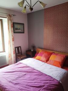 a bedroom with a large bed with colorful sheets at Gîte "À Moussey vous" in Moussey