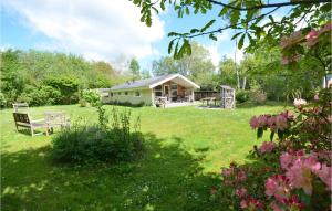 a house in the middle of a yard with a bench at Holiday Home Øreflak Ebeltoft Vi in Ebeltoft +18 photos