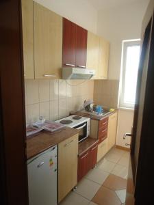 a kitchen with wooden cabinets and a stove top oven at Apartments Elizabet in Star Dojran