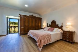 a bedroom with a large bed and a balcony at Casa de Valente - Camariñas in Camariñas