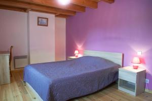 a bedroom with purple walls and a bed with two tables at Gîte Gîte Le Pré de Chabanettes 6/8 personnes in Termes