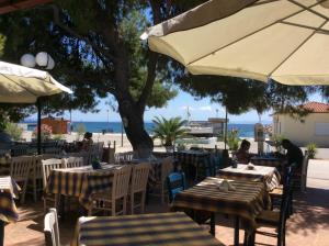 a restaurant with tables and chairs with the beach in the background at Marinas House in Skála Nikíta