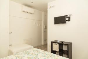 a bedroom with a bed and a tv on a wall at Palinuro Casa Vacanza Melita in Palinuro