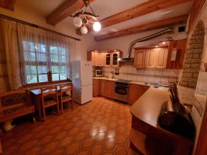 a kitchen with a table and a white refrigerator at Zabytkowa Karczma in Jedwabno