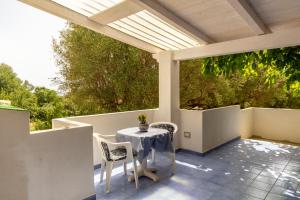 a patio with a table and chairs on a roof at Palinuro Casa Vacanza Melita in Palinuro