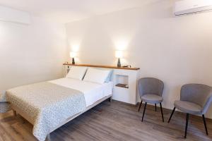 una camera da letto con un letto e due sedie di Al Rustico a Torbole