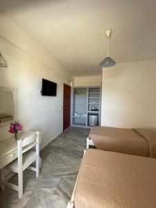 a hotel room with two beds and a television at Village Twins 1 in Ios Chora