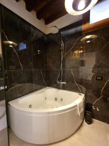 a bath tub in a bathroom with black tiles at San Marco 3097 - LuxuryJacuzzi in Venice