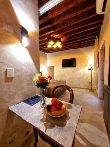 a table with a bowl of fruit and a vase of flowers at San Marco 3097 - LuxuryJacuzzi in Venice