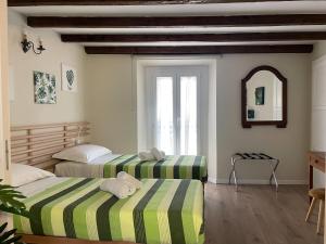 due letti in una stanza con finestra di Dimora Romantica apartment a Bellagio