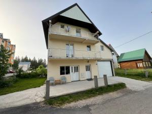 une maison avec un balcon sur le côté dans l'établissement Apartman Jezera, à Žabljak