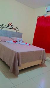 ノブレスにあるCasa flôr de lavandaの赤いカーテンが付いた部屋のベッド1台