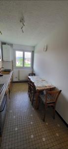 Una habitación con una mesa y sillas en una cocina. en le repère Gerardmer, en Gérardmer