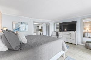 een slaapkamer met een groot bed en een televisie bij New Oceanview Suite - Caravelle 504 in Myrtle Beach