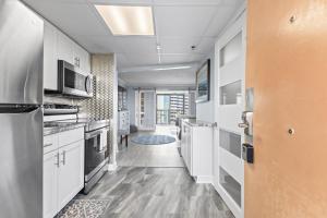 een keuken met witte kasten en roestvrijstalen apparaten bij New Oceanview Suite - Caravelle 504 in Myrtle Beach