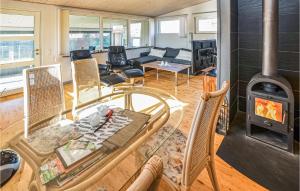 a living room with a glass table and a wood stove at Two-Bedroom Holiday Home Broager With A Fireplace 07 in Broager