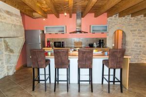 a kitchen with an island with bar stools at Gîte " la prairie" in La Canourgue