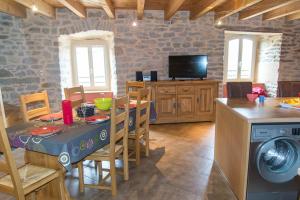 a living room with a table and a kitchen at Gîte " la prairie" in La Canourgue
