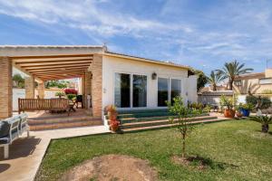 una pequeña casa con terraza y banco en Villa Los Balcones, en Torrevieja
