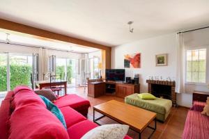 Una sala de estar con un sofá rojo y una chimenea. en Villa Los Balcones, en Torrevieja