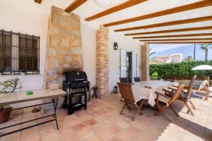 Un patio con mesa y sillas y una estufa. en Villa Los Balcones, en Torrevieja