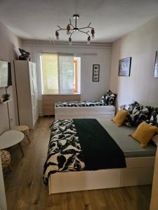 a bedroom with two beds and a table and a window at Sreća Plitvice in Plitvička Jezera