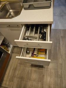 a kitchen drawer filled with tools and a sink at Sreća Plitvice in Plitvička Jezera